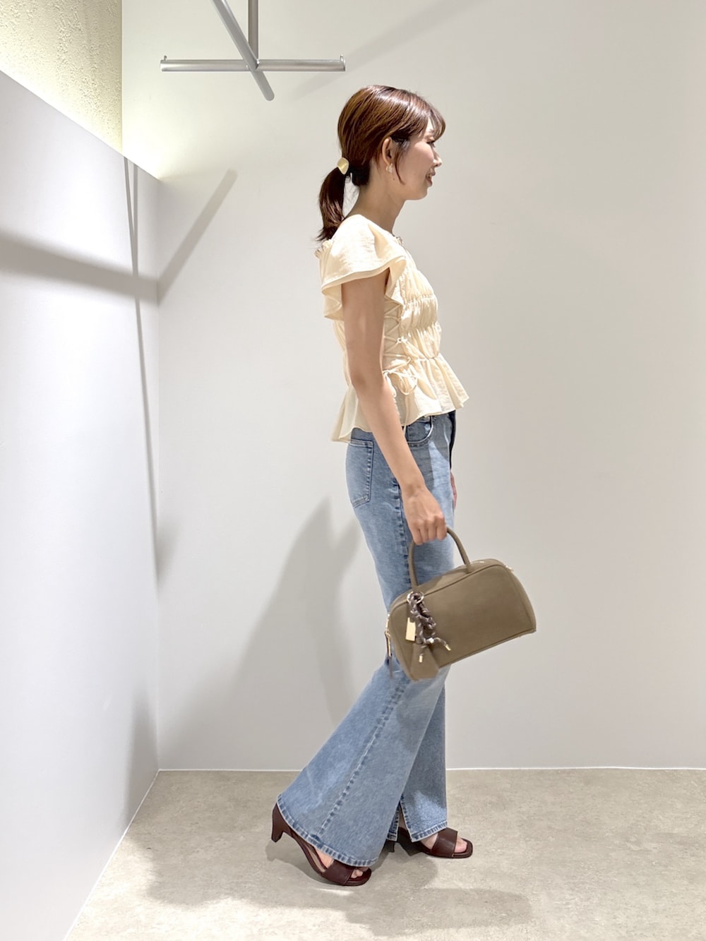 ピンク系のシャツ/ブラウス、ブルー系のデニムパンツ、ブラック系のボストンバッグを着用したレディースの夏コーディネートの5枚目の写真