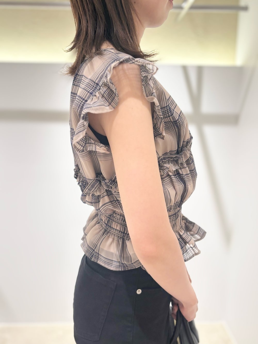 ベージュ系のシャツ/ブラウス、ブラック系のデニムパンツ、ブラック系のボストンバッグを着用したレディースの夏コーディネートの6枚目の写真