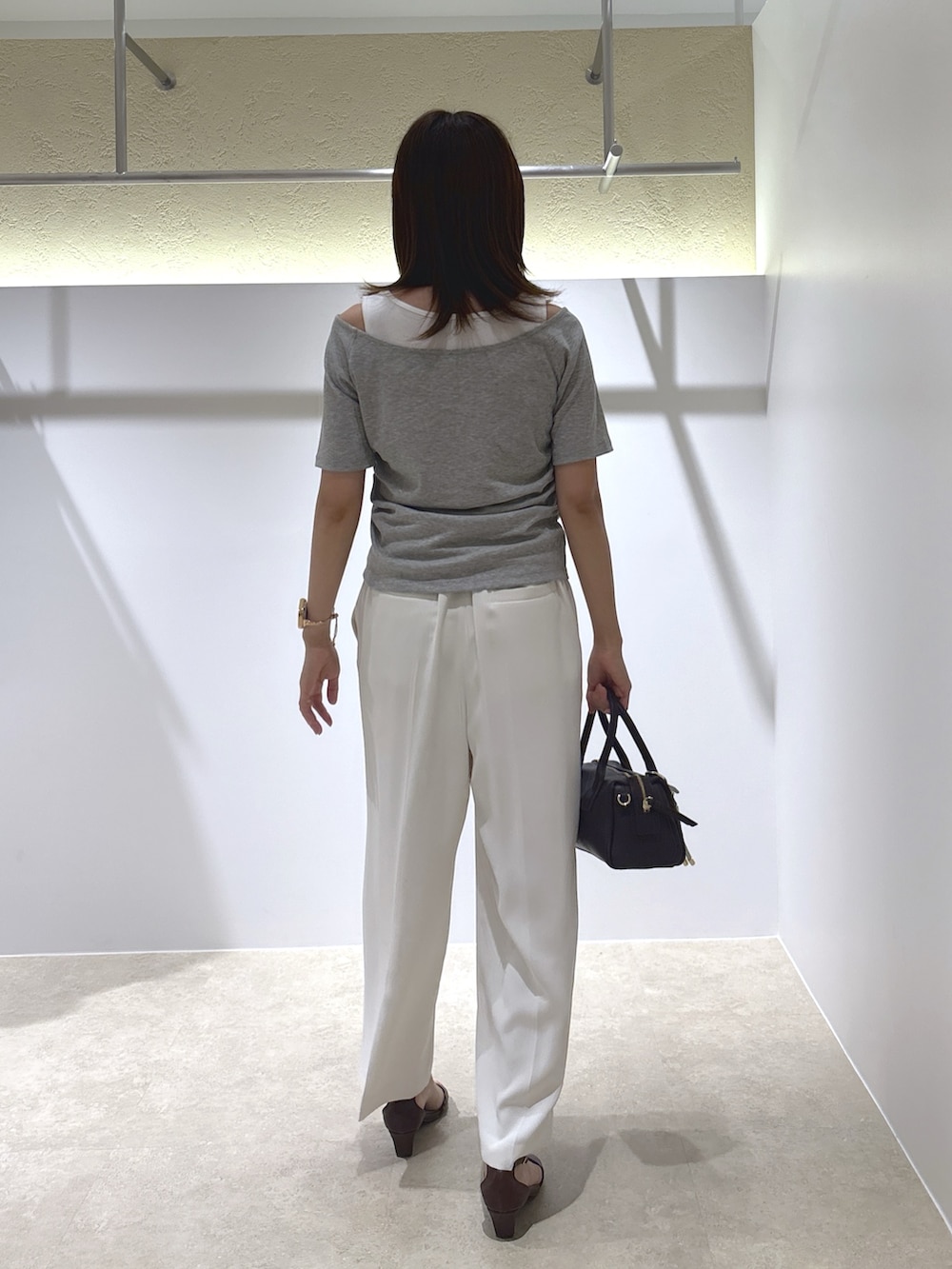 グレー系のTシャツ/カットソー、ホワイト系のその他パンツ、ブラック系のボストンバッグを着用したレディースの夏コーディネートの4枚目の写真