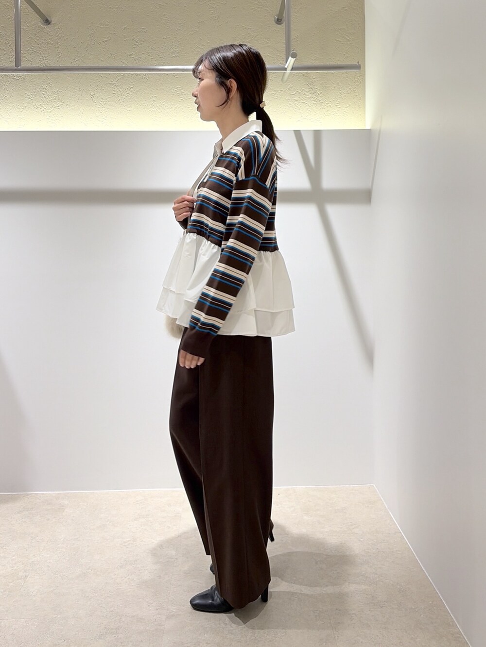 ブラウン系のニット/セーター、ブラウン系のその他パンツ、ホワイト系のショルダーバッグを着用したレディースの秋コーディネートの2枚目の写真