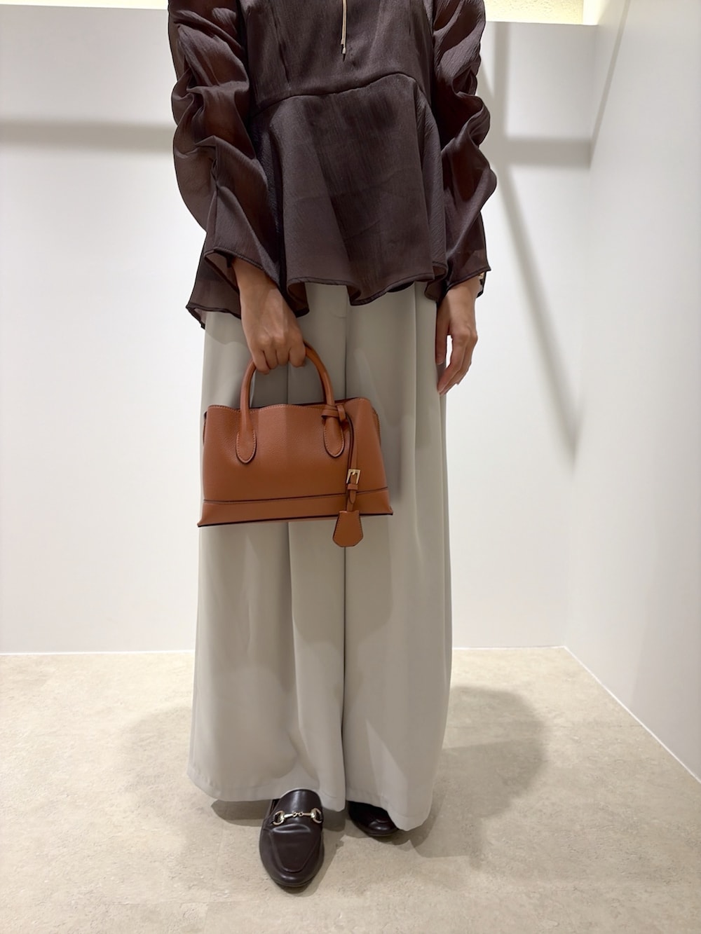 ブラウン系のシャツ/ブラウス、ベージュ系のその他パンツ、ブラック系のトートバッグを着用したレディースの秋コーディネートの8枚目の写真