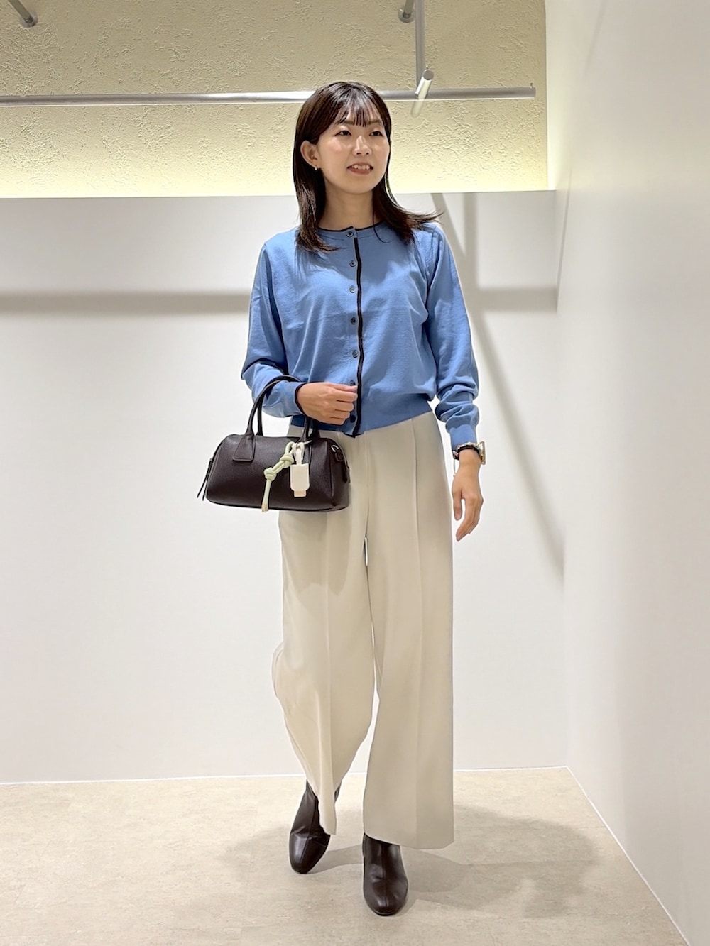 ブルー系のカーディガン/ボレロ、ホワイト系のその他パンツ、ブラウン系のブーツを着用したレディースの秋コーディネートの4枚目の写真