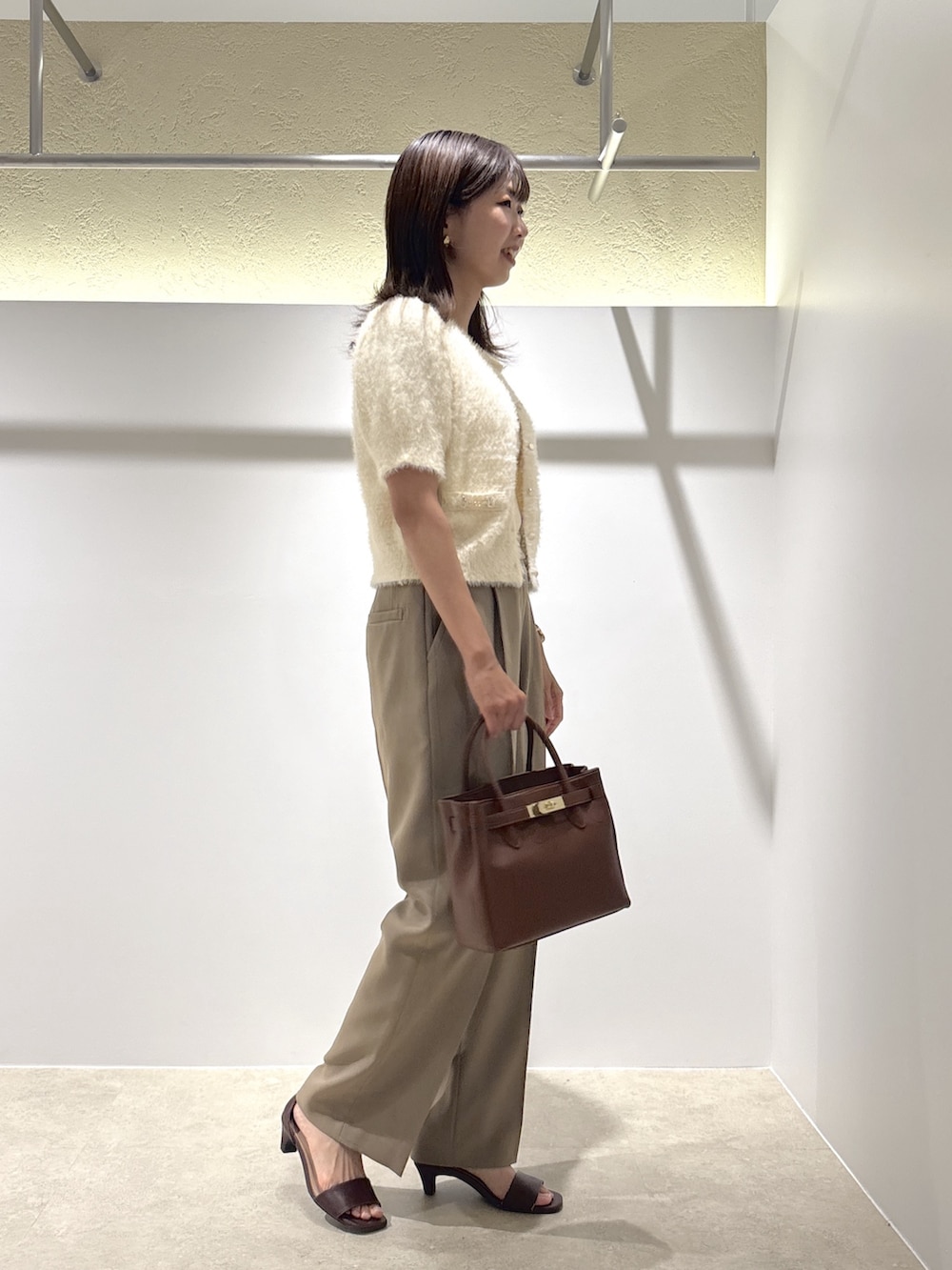 ホワイト系のニット/セーター、ベージュ系のその他パンツ、イエロー系のトートバッグを着用したレディースの夏コーディネートの3枚目の写真