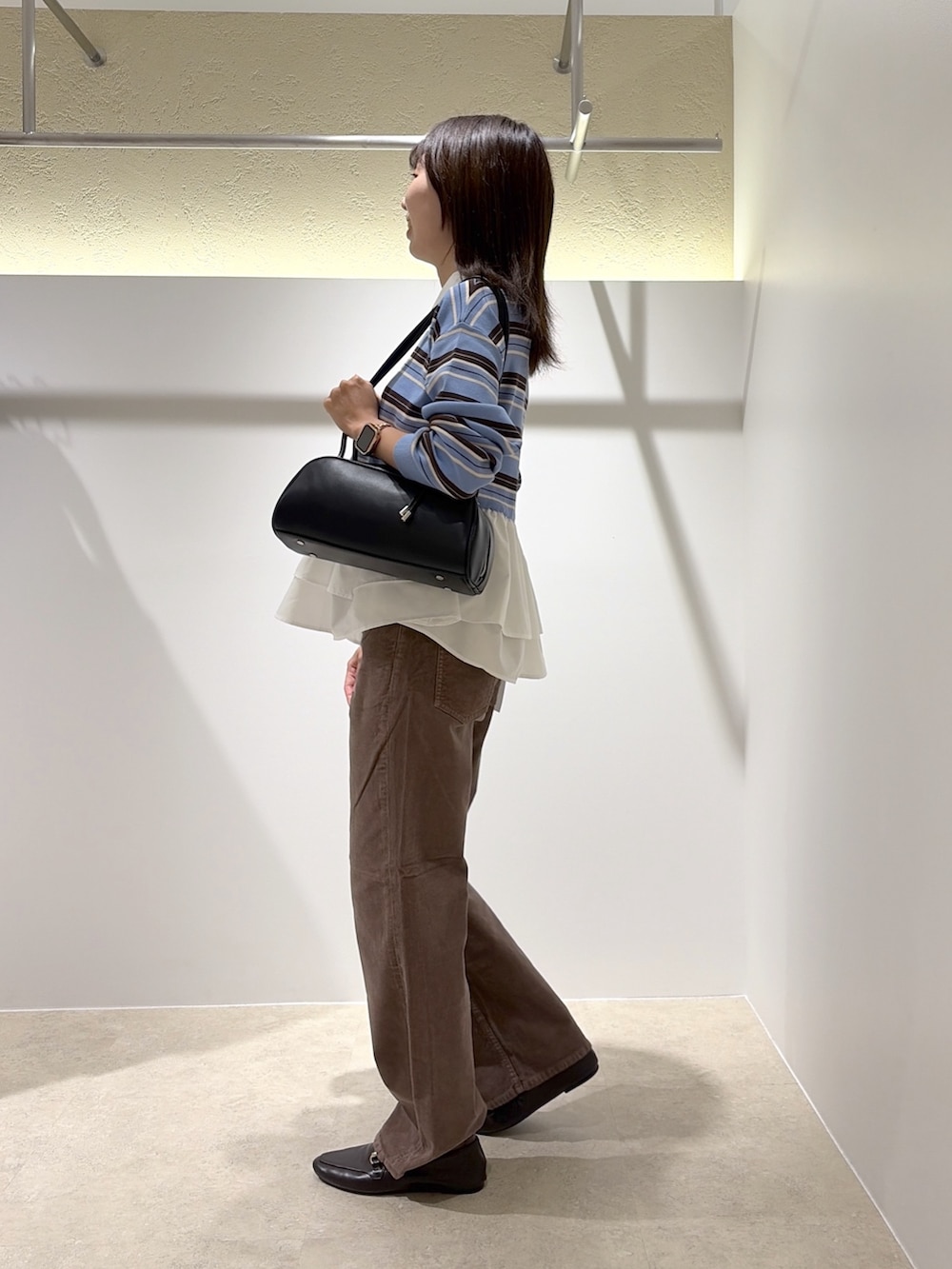 ブルー系のニット/セーター、ブラウン系のその他パンツ、ブラウン系のローファーを着用したレディースの秋コーディネートの2枚目の写真