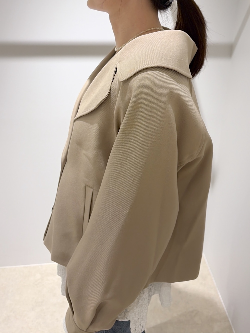 ベージュ系のトレンチコート、ホワイト系のTシャツ/カットソー、ブラック系のデニムパンツを着用したレディースの秋コーディネートの7枚目の写真