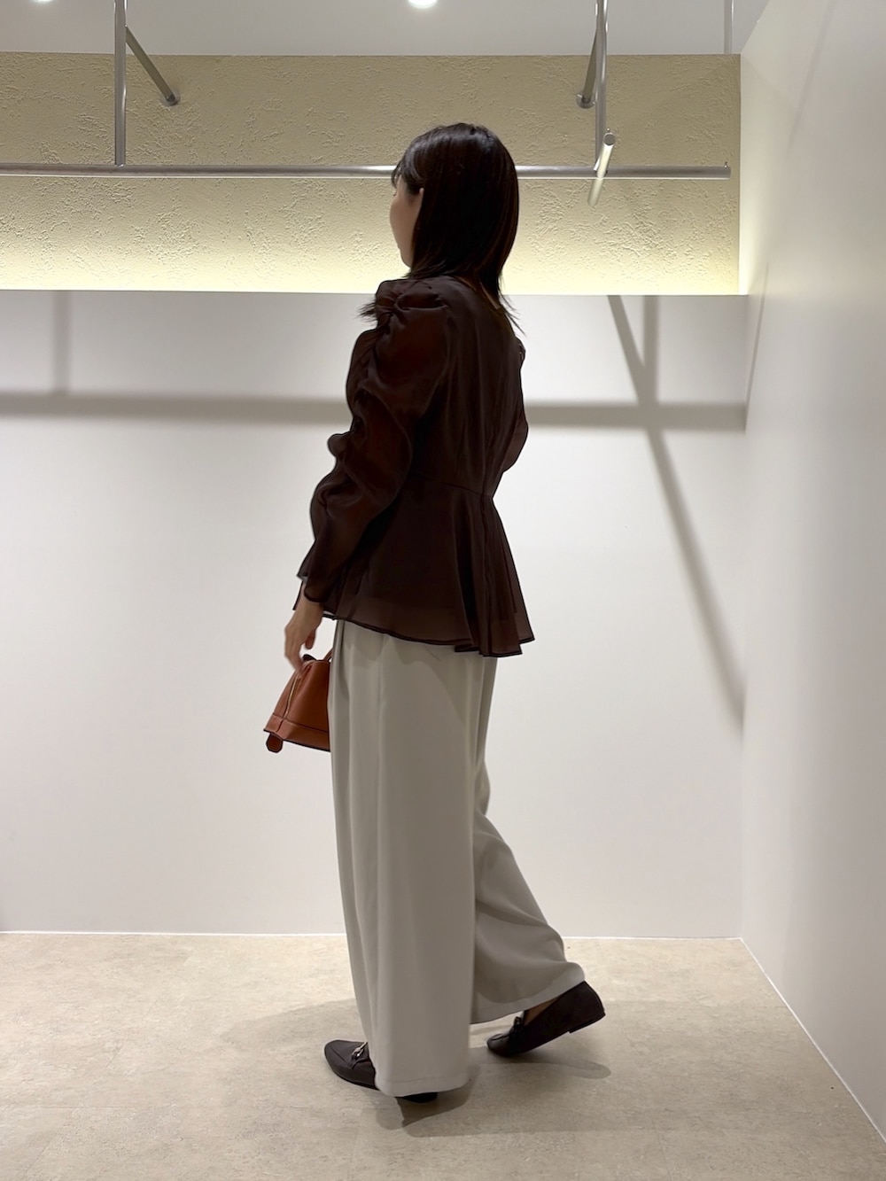 ブラウン系のシャツ/ブラウス、ベージュ系のその他パンツ、ブラック系のトートバッグを着用したレディースの秋コーディネートの2枚目の写真