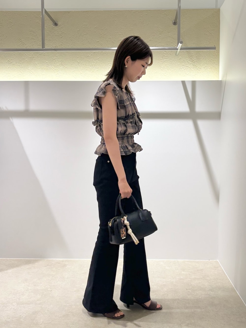 ベージュ系のシャツ/ブラウス、ブラック系のデニムパンツ、ブラック系のボストンバッグを着用したレディースの夏コーディネートの4枚目の写真