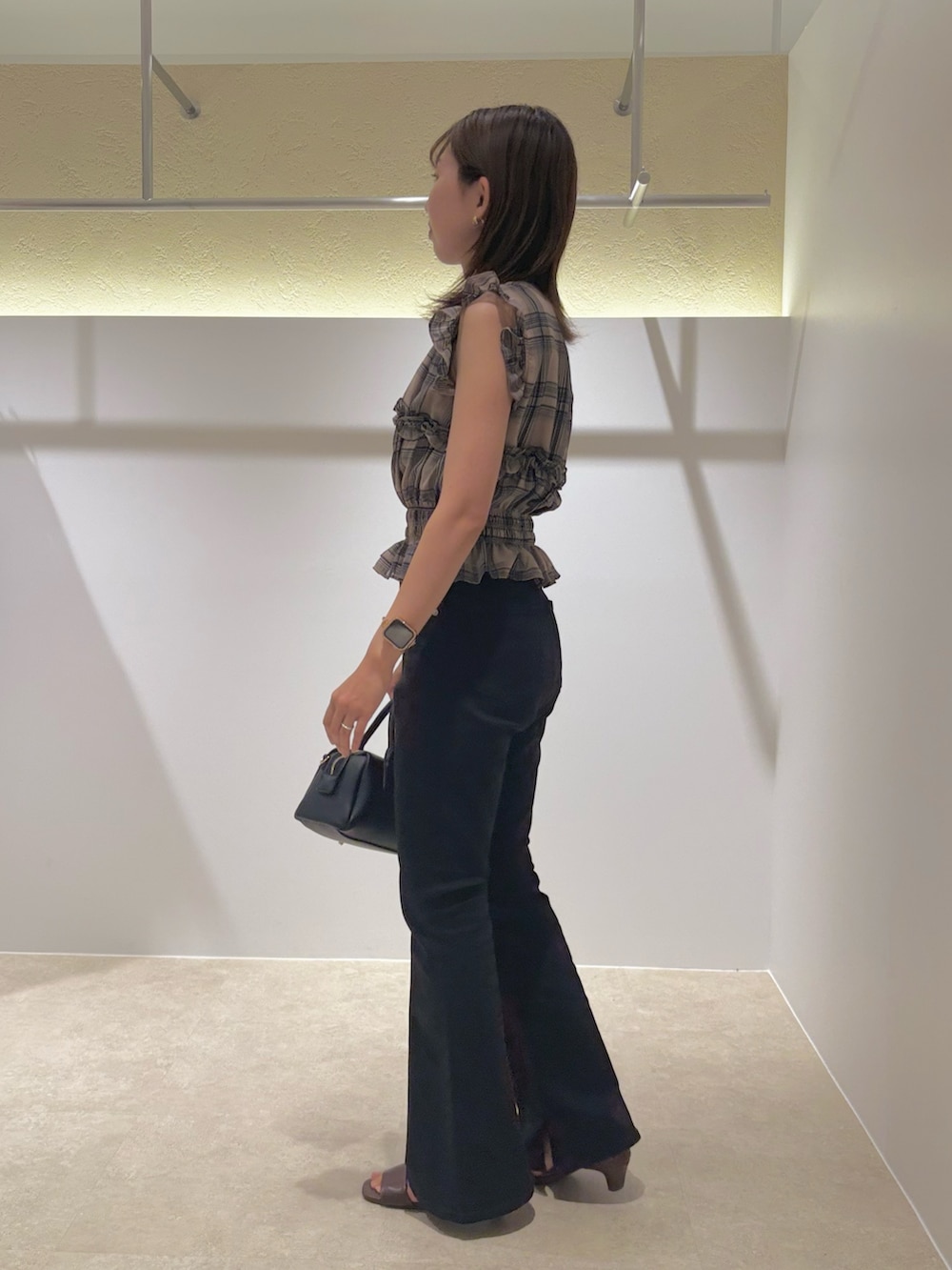 ベージュ系のシャツ/ブラウス、ブラック系のデニムパンツ、ブラック系のボストンバッグを着用したレディースの夏コーディネートの2枚目の写真