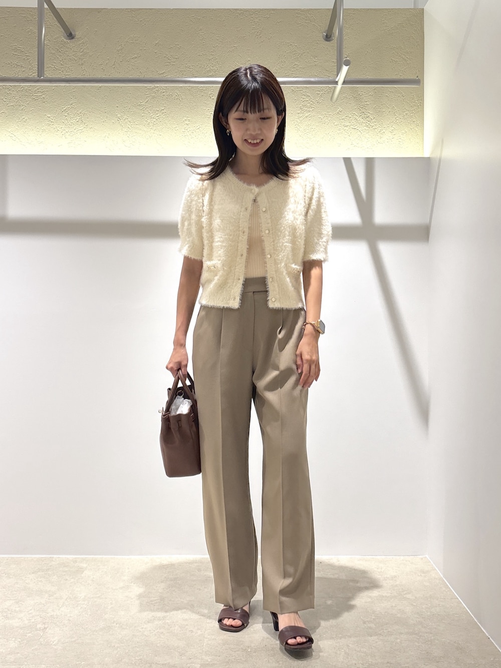 ホワイト系のニット/セーター、ベージュ系のその他パンツ、イエロー系のトートバッグを着用したレディースの夏コーディネートの2枚目の写真