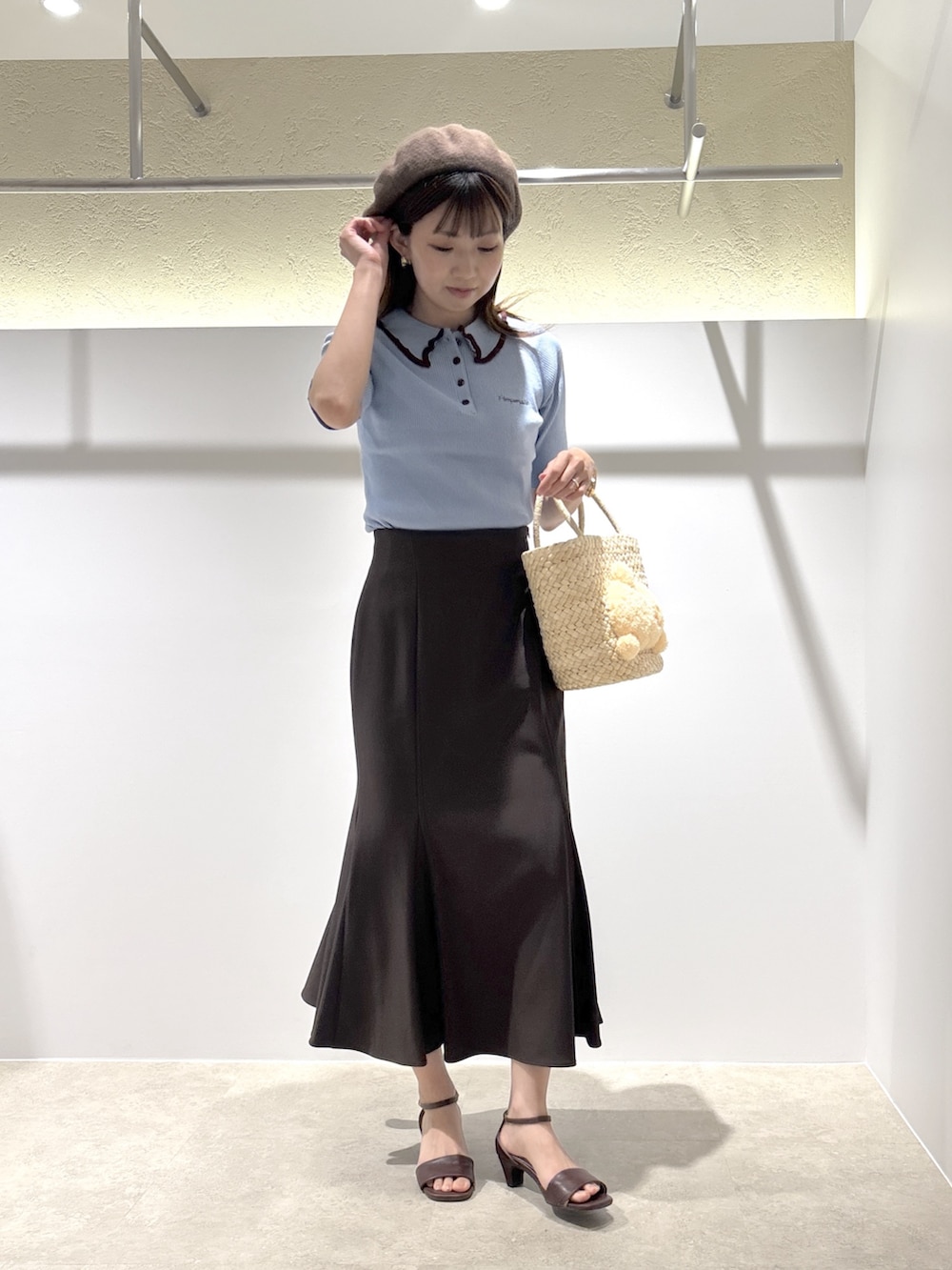 ブラウン系のサンダル、ベージュ系のバッグ、ブルー系のトップスを着用したレディースの夏コーディネートの2枚目の写真