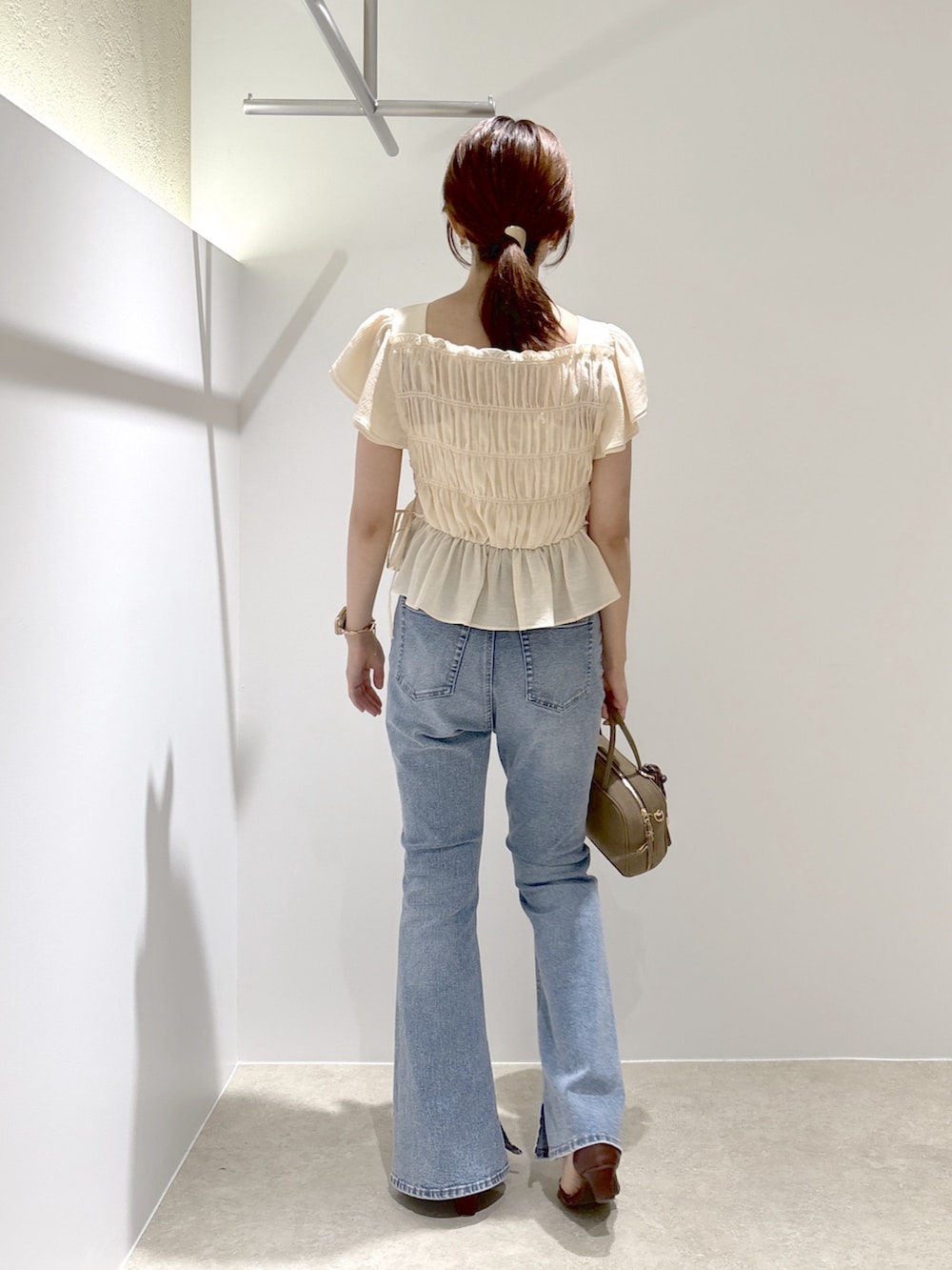 ピンク系のシャツ/ブラウス、ブルー系のデニムパンツ、ブラック系のボストンバッグを着用したレディースの夏コーディネートの4枚目の写真