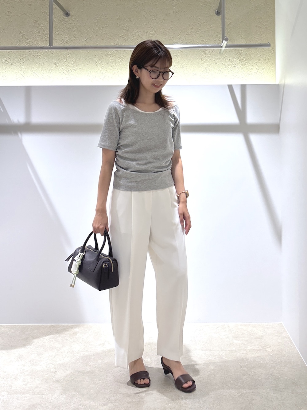グレー系のTシャツ/カットソー、ホワイト系のその他パンツ、ブラック系のボストンバッグを着用したレディースの夏コーディネートの2枚目の写真