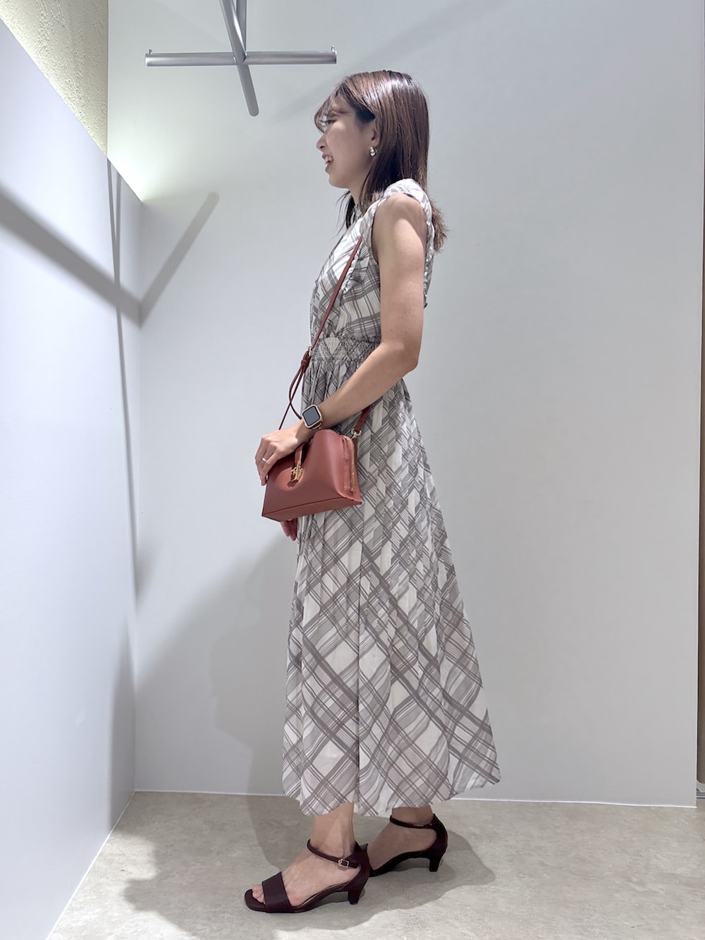 ベージュ系のワンピース、レッド系のショルダーバッグ、ブラウン系のサンダルを着用したレディースの夏コーディネートの3枚目の写真