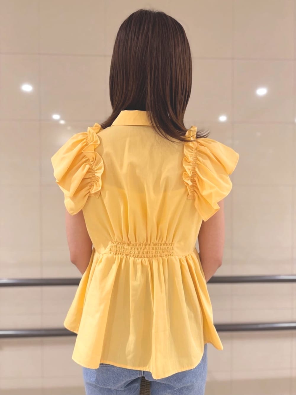 イエロー系のシャツ/ブラウス、ベージュ系のかごバッグ、ブルー系のデニムパンツを着用したレディースの夏コーディネートの6枚目の写真