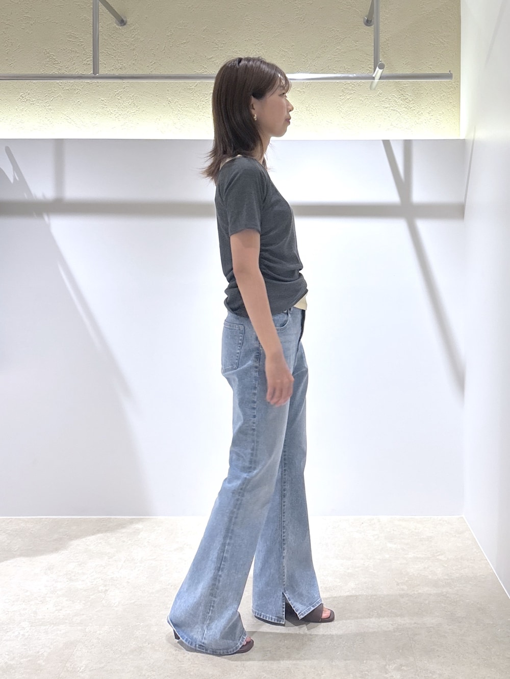 グレー系のTシャツ/カットソー、ブルー系のデニムパンツ、ブラウン系のサンダルを着用したレディースの夏コーディネートの4枚目の写真