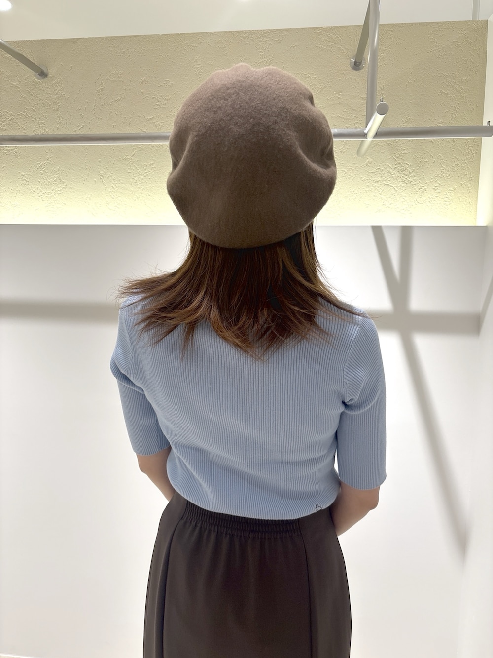ブラウン系のサンダル、ベージュ系のバッグ、ブルー系のトップスを着用したレディースの夏コーディネートの7枚目の写真