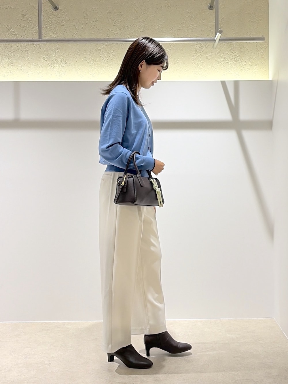 ブルー系のカーディガン/ボレロ、ホワイト系のその他パンツ、ブラウン系のブーツを着用したレディースの秋コーディネートの3枚目の写真