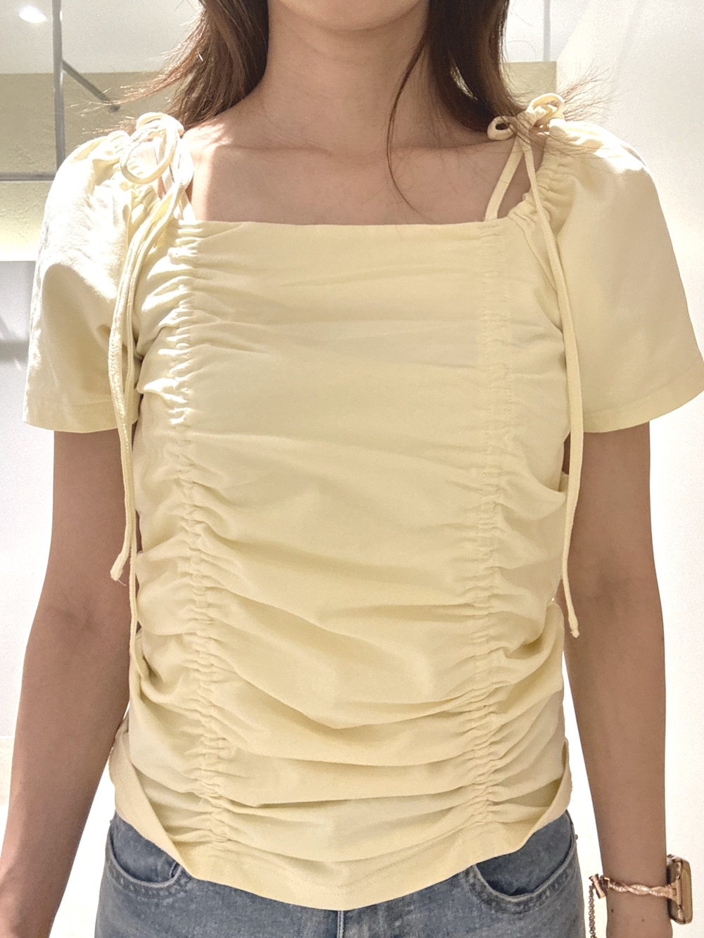 イエロー系のTシャツ/カットソー、ブルー系のデニムパンツ、ブラウン系のサンダルを着用したレディースの夏コーディネートの4枚目の写真