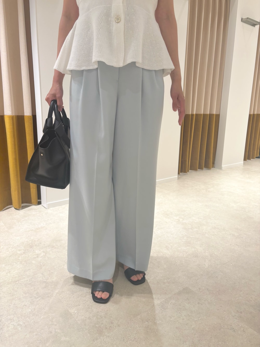 ホワイト系のベスト、ブルー系のその他パンツ、ブラック系のサンダルを着用したレディースの夏コーディネートの6枚目の写真