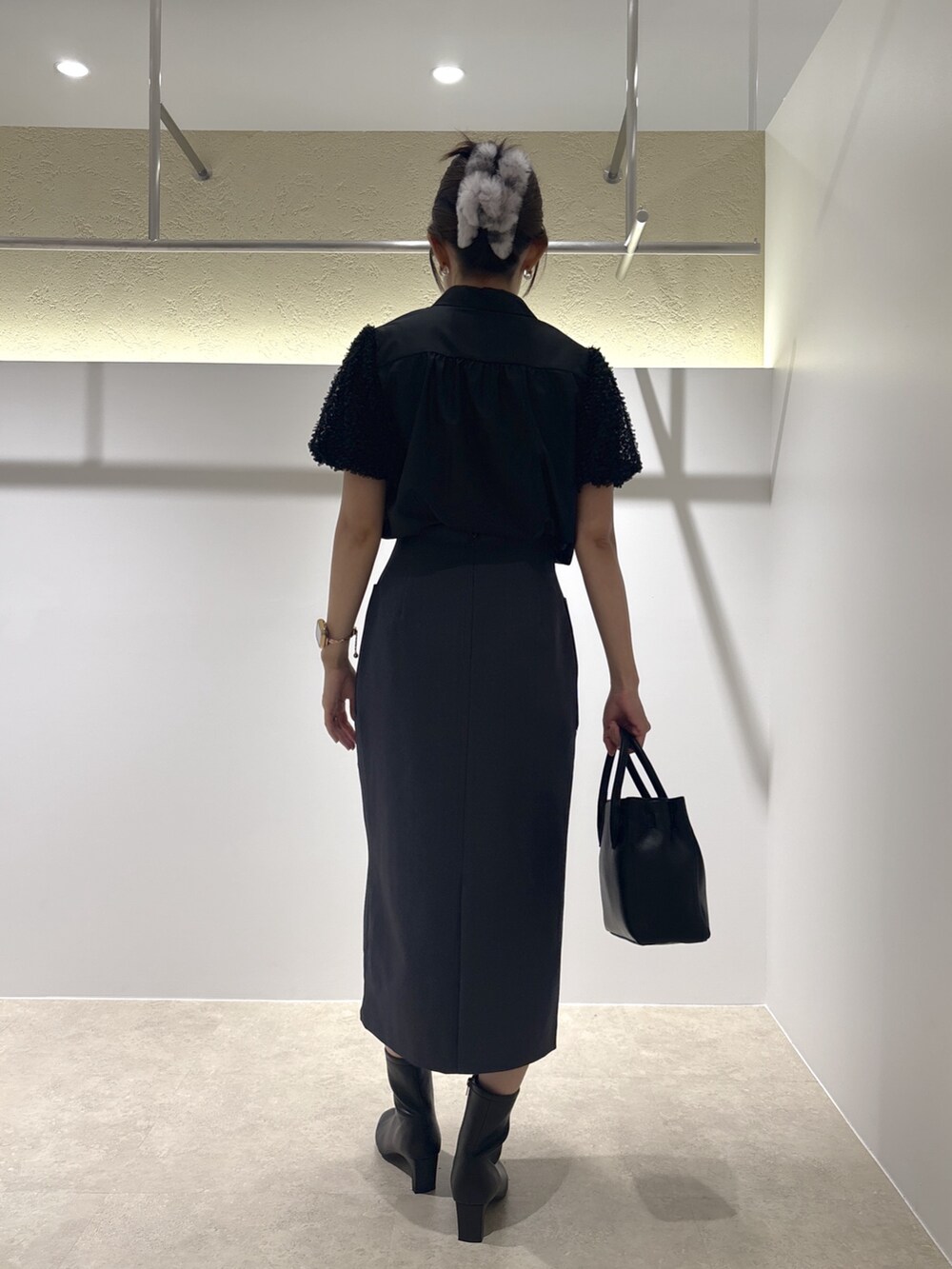 ブラック系のシャツ/ブラウス、ブラック系のトートバッグ、ブラック系のブーツを着用したレディースの夏コーディネートの3枚目の写真