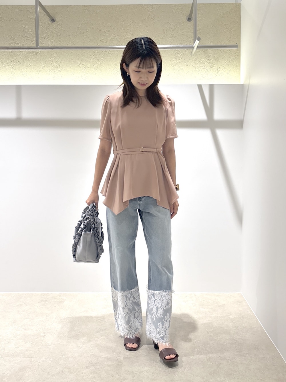 ピンク系のシャツ/ブラウス、ブルー系のデニムパンツ、ブラウン系のサンダルを着用したレディースの夏コーディネートの2枚目の写真