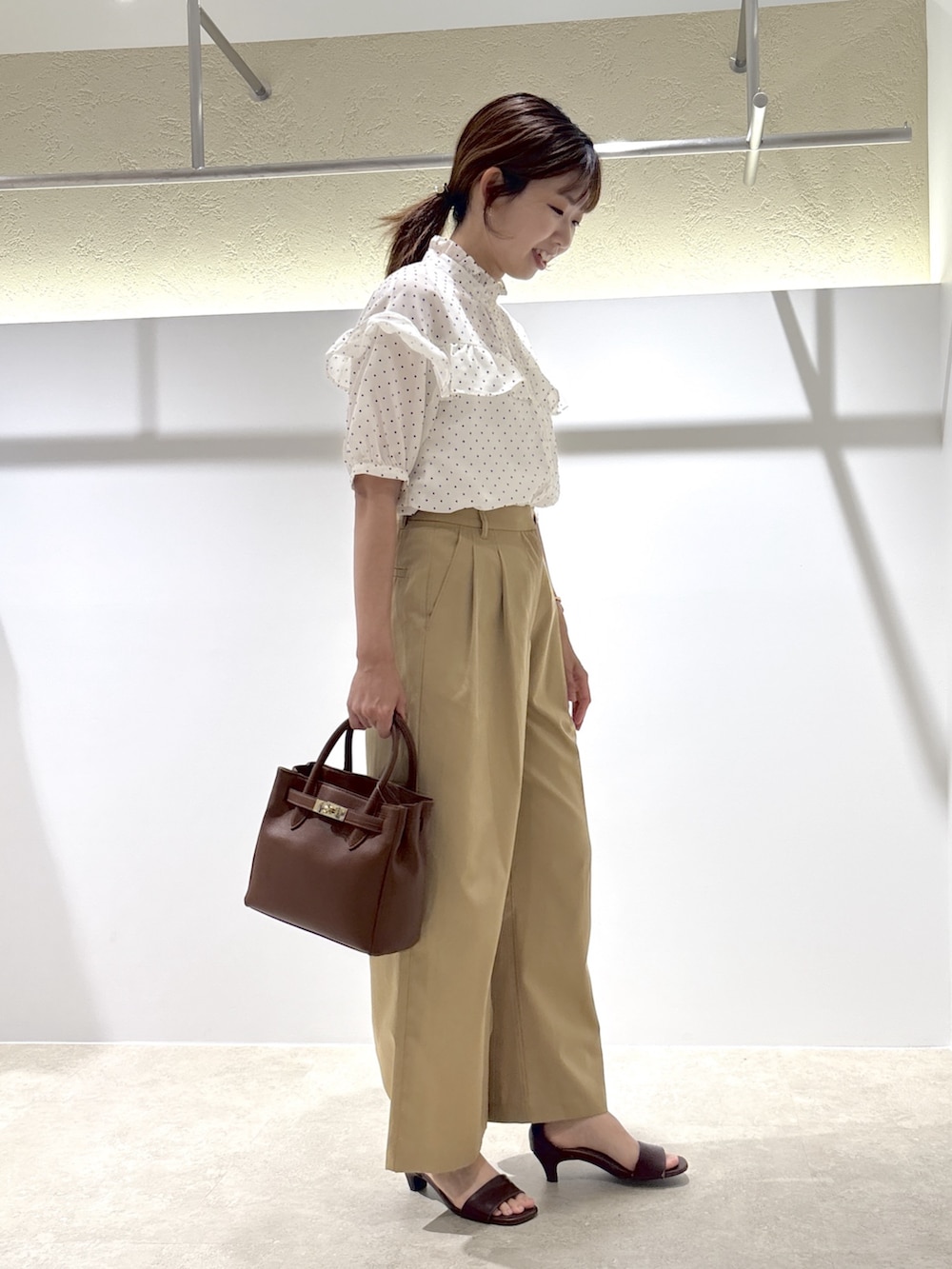 ホワイト系のシャツ/ブラウス、ベージュ系のその他パンツ、ブラウン系のサンダルを着用したレディースの夏コーディネートの2枚目の写真