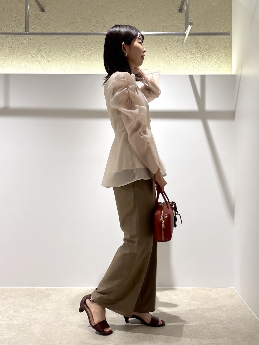 ベージュ系のシャツ/ブラウス、イエロー系のその他パンツ、ブラウン系のサンダルを着用したレディースの秋コーディネートの2枚目の写真