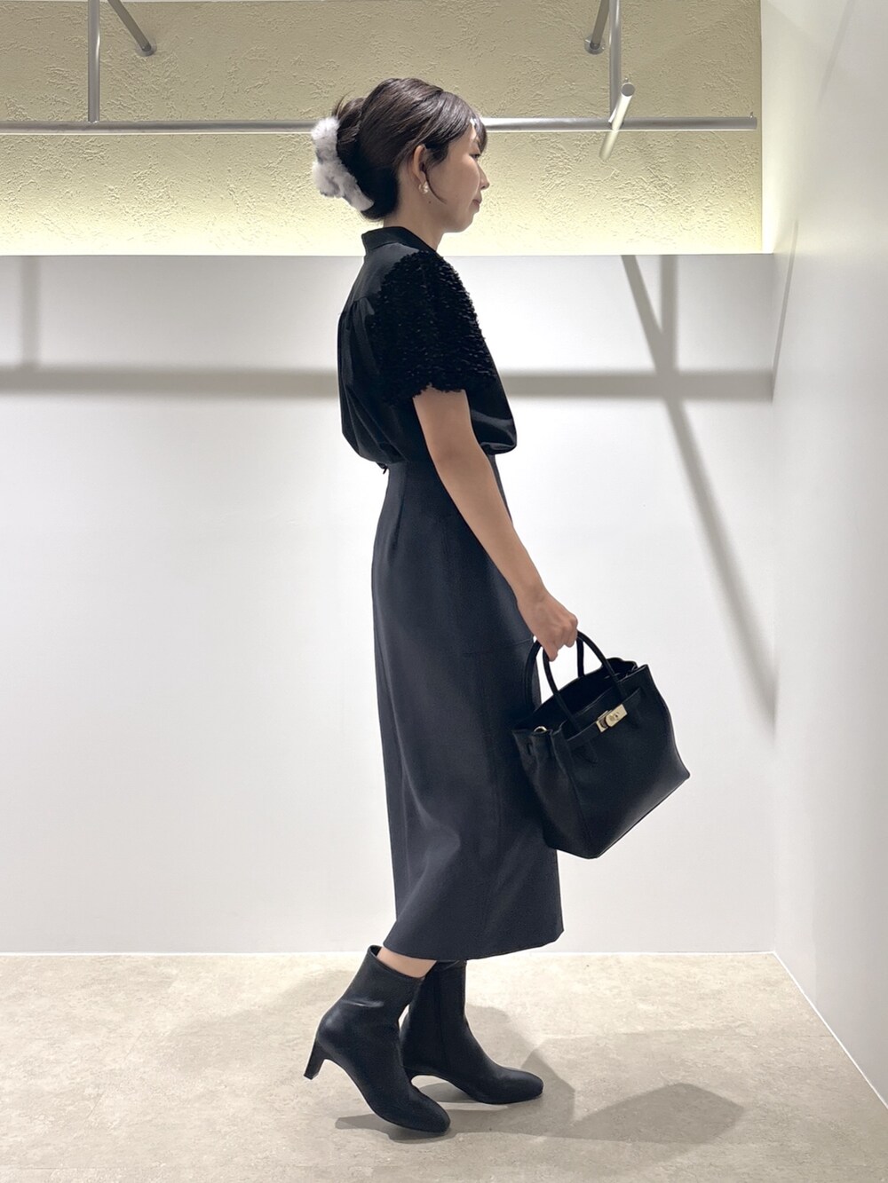 ブラック系のシャツ/ブラウス、ブラック系のトートバッグ、ブラック系のブーツを着用したレディースの夏コーディネートの4枚目の写真