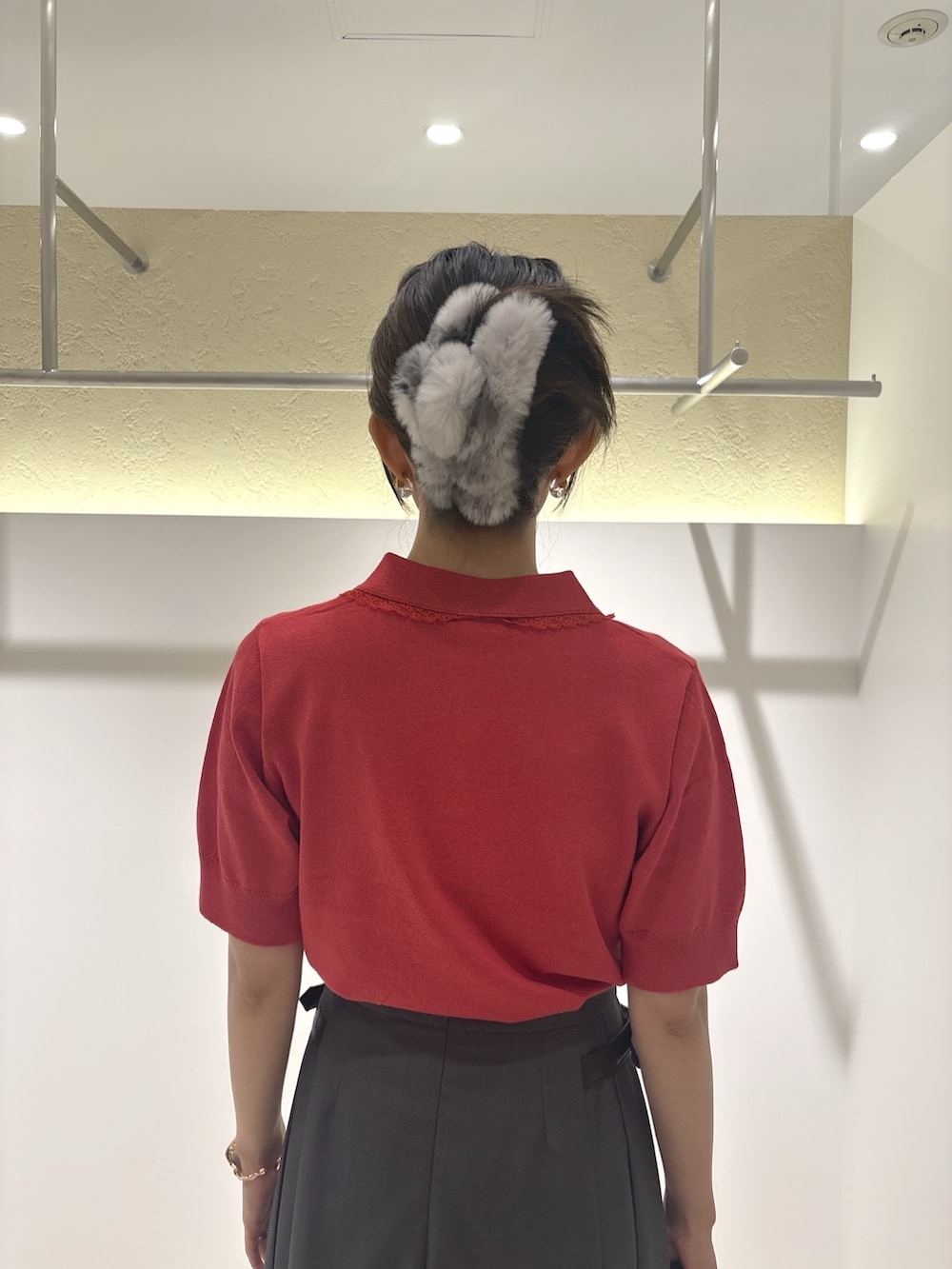 レッド系のニット/セーター、グレー系のスカート、ブラック系のブーツを着用したレディースの夏コーディネートの7枚目の写真
