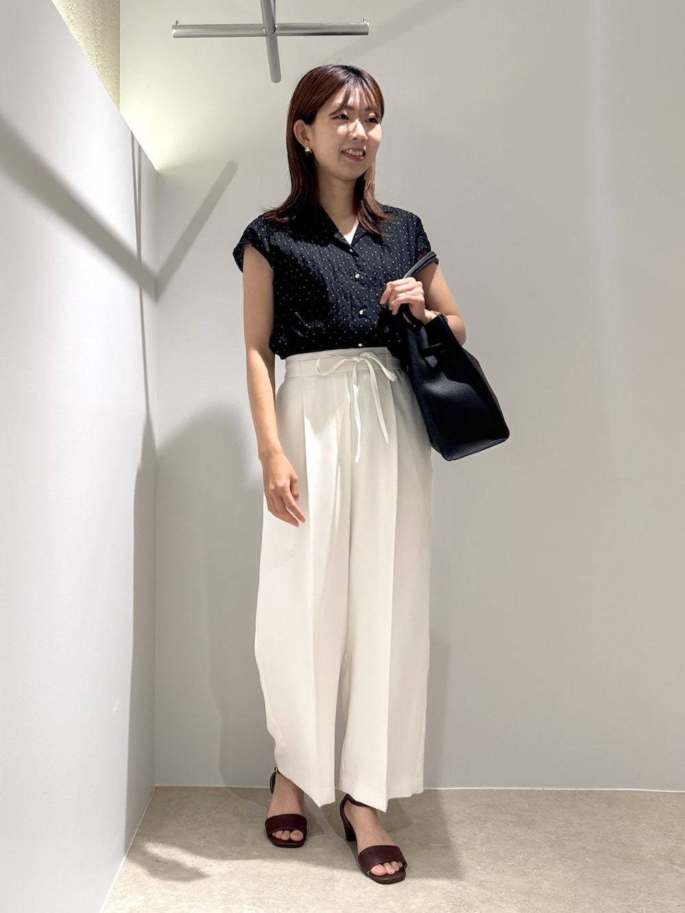 ブラック系のシャツ/ブラウス、ホワイト系のその他パンツ、ブラウン系のサンダルを着用したレディースの夏コーディネートの2枚目の写真