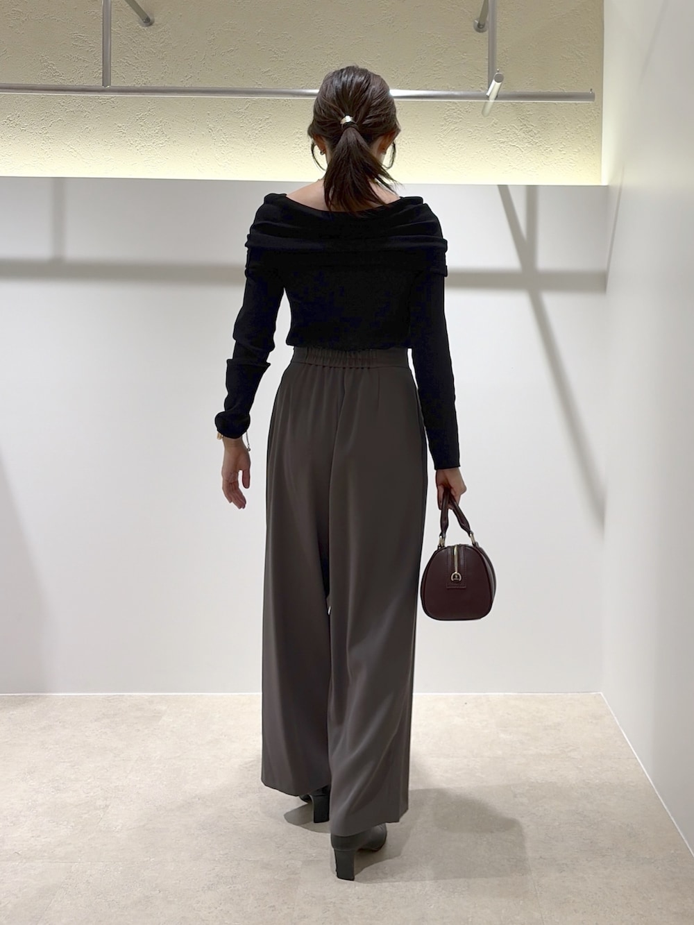 ブラック系のニット/セーター、グレー系のその他パンツ、ブラウン系のブーツを着用したレディースの秋コーディネートの3枚目の写真