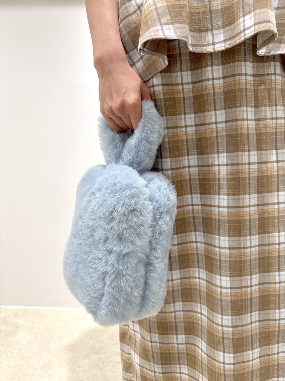 ベージュ系のセットアップ、ブラウン系のサンダル、ブルー系のニット/セーターを着用したレディースの夏コーディネートの8枚目の写真