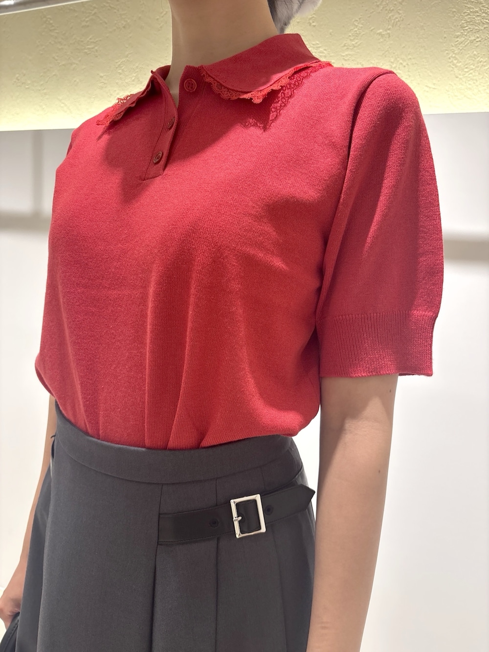 レッド系のニット/セーター、グレー系のスカート、ブラック系のブーツを着用したレディースの夏コーディネートの6枚目の写真