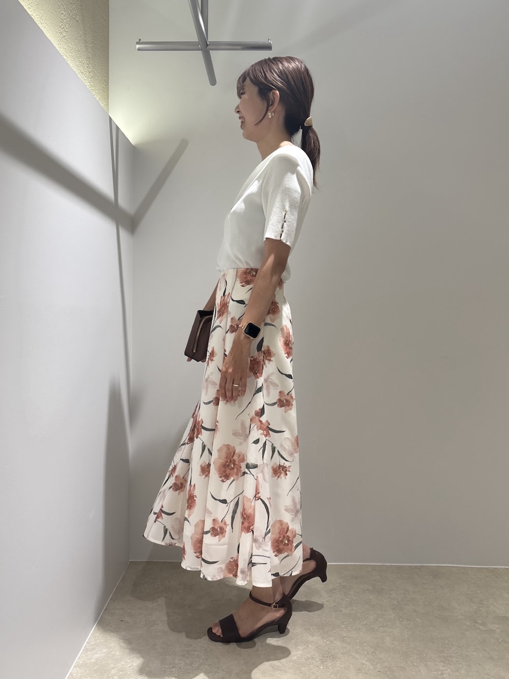 ホワイト系のニット/セーター、ベージュ系のスカート、ブラウン系のサンダルを着用したレディースの夏コーディネートの3枚目の写真