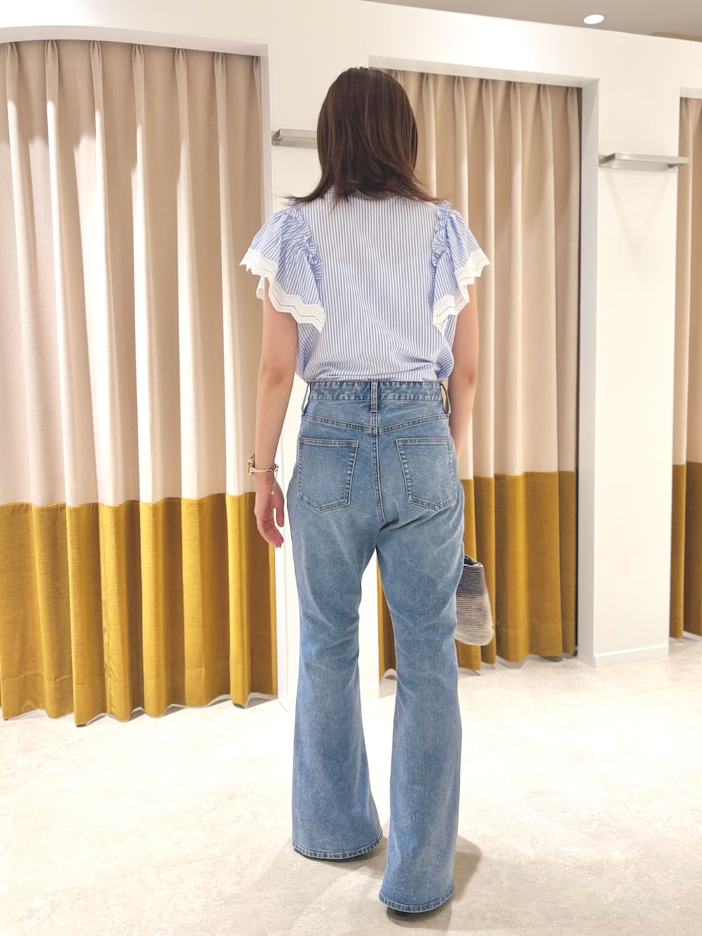 ブラウン系のサンダル、ブルー系のデニムパンツ、シルバー系のハンドバッグを着用したレディースの夏コーディネートの3枚目の写真