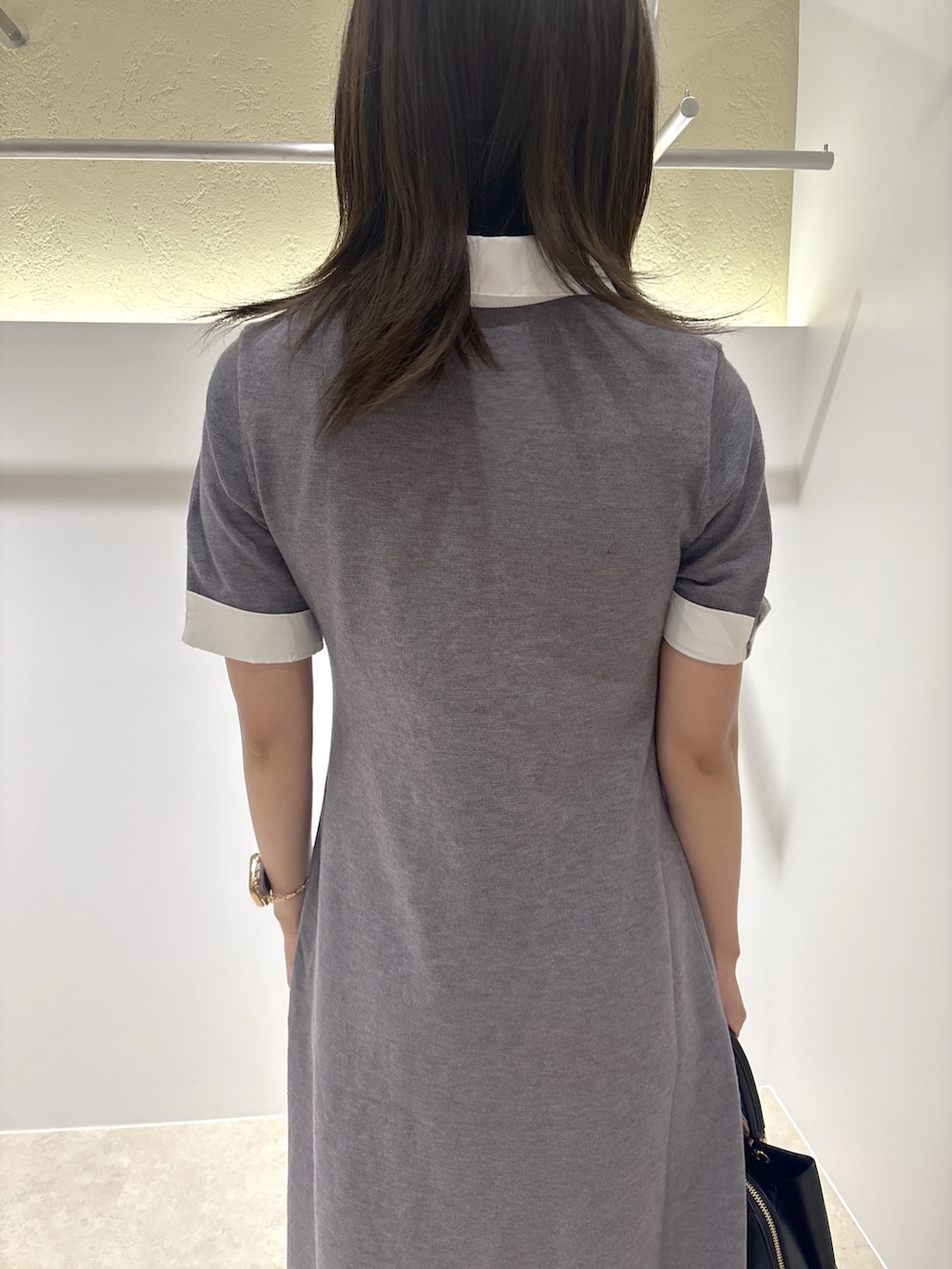 グレー系のワンピース、ブラック系のブーツ、ブラック系のトートバッグを着用したレディースの夏コーディネートの6枚目の写真