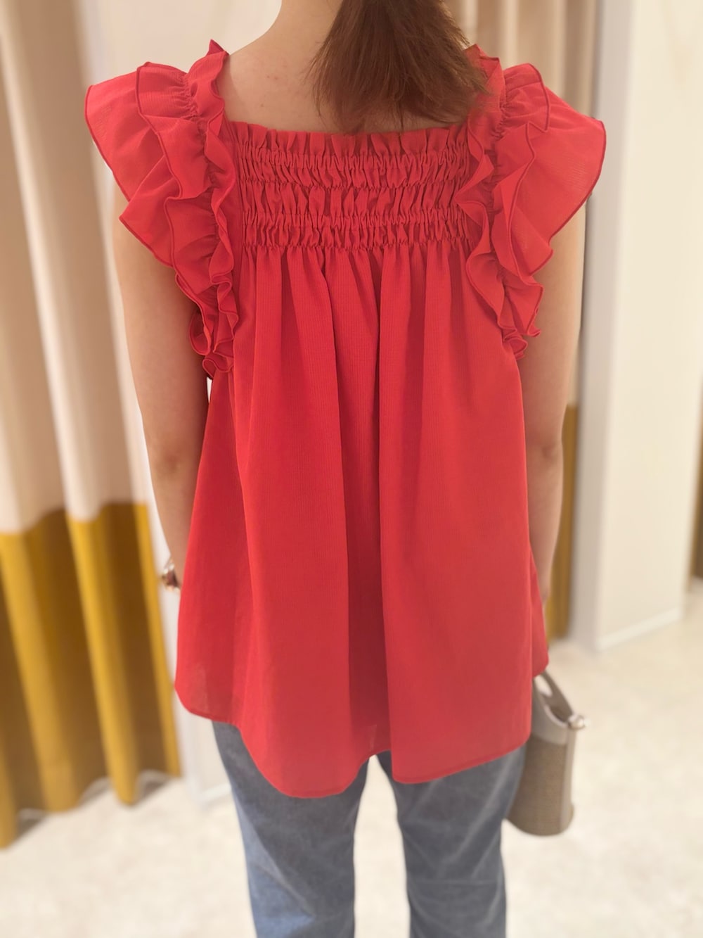 レッド系のシャツ/ブラウス、ベージュ系のバッグ、ブラウン系のサンダルを着用したレディースの夏コーディネートの7枚目の写真