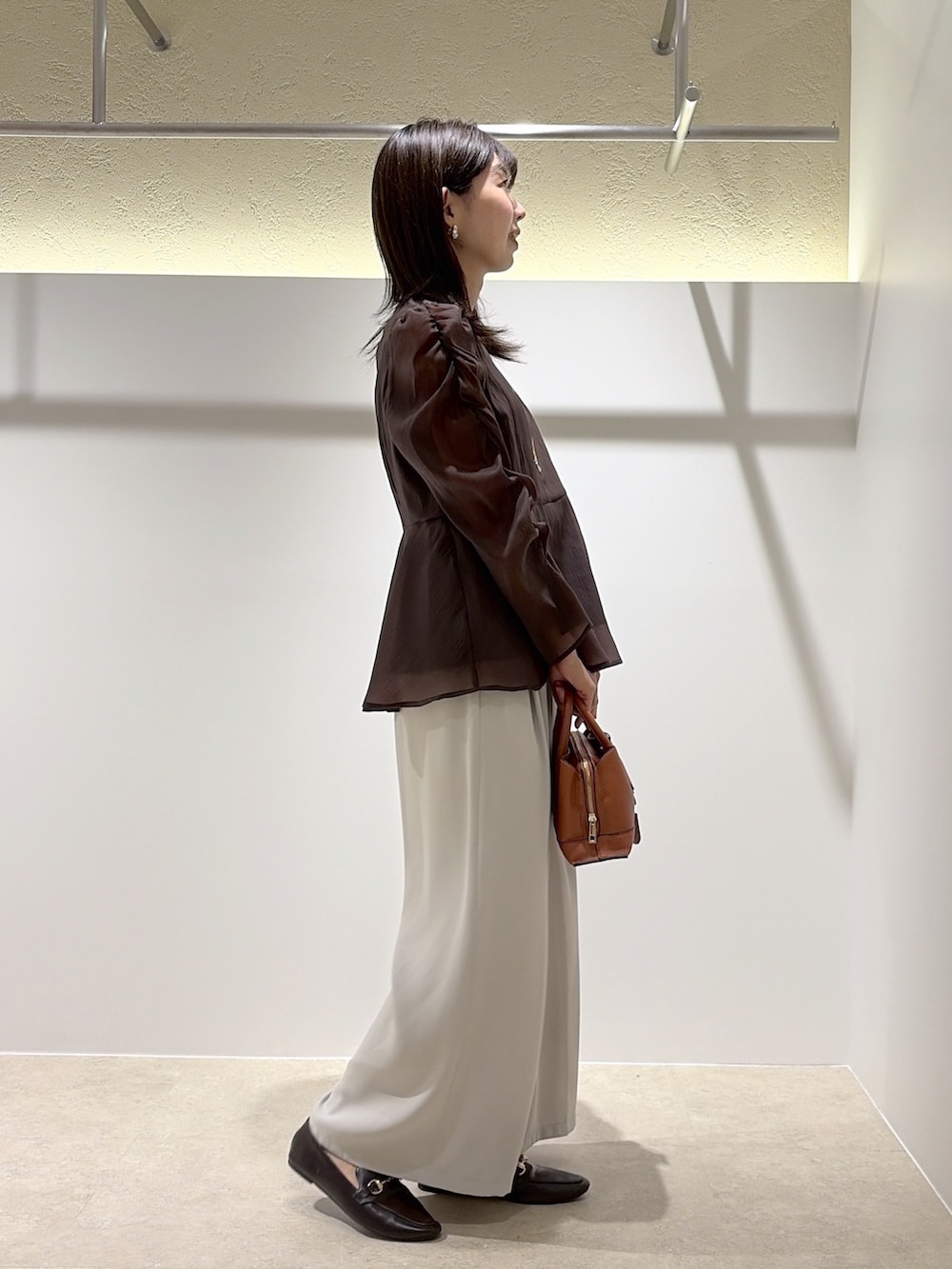 ブラウン系のシャツ/ブラウス、ベージュ系のその他パンツ、ブラック系のトートバッグを着用したレディースの秋コーディネートの4枚目の写真