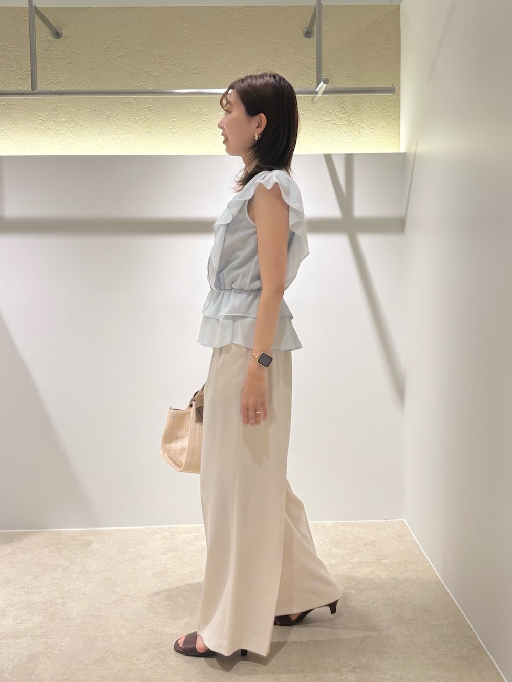 ブルー系のシャツ/ブラウス、ホワイト系のその他パンツ、ホワイト系のトートバッグを着用したレディースの夏コーディネートの2枚目の写真