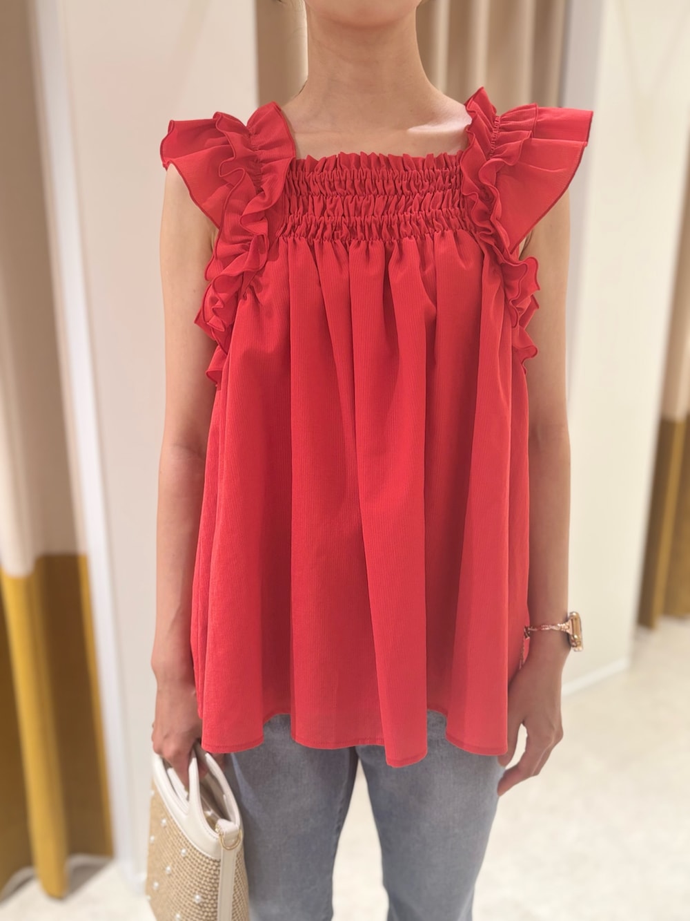 レッド系のシャツ/ブラウス、ベージュ系のバッグ、ブラウン系のサンダルを着用したレディースの夏コーディネートの5枚目の写真