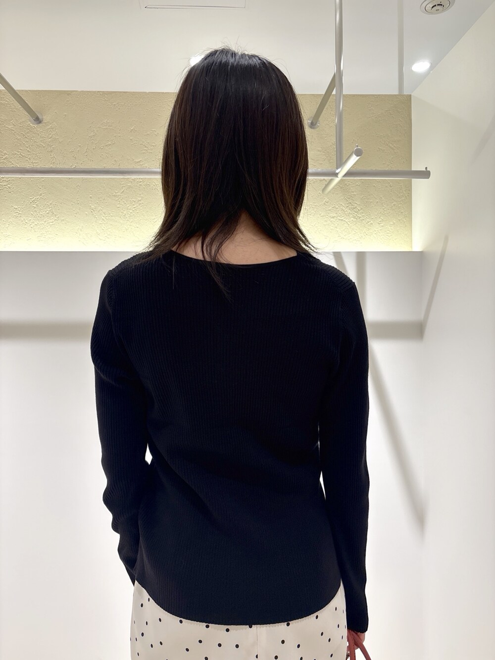 ブラック系のカーディガン/ボレロ、ブラック系のブーツ、ホワイト系のスカートを着用したレディースの秋コーディネートの7枚目の写真