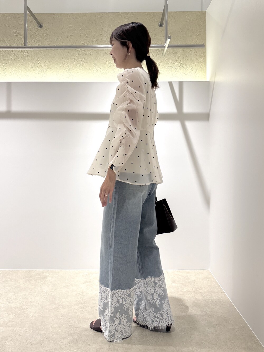 ホワイト系のシャツ/ブラウス、ブルー系のデニムパンツ、ブラウン系のサンダルを着用したレディースの夏コーディネートの2枚目の写真