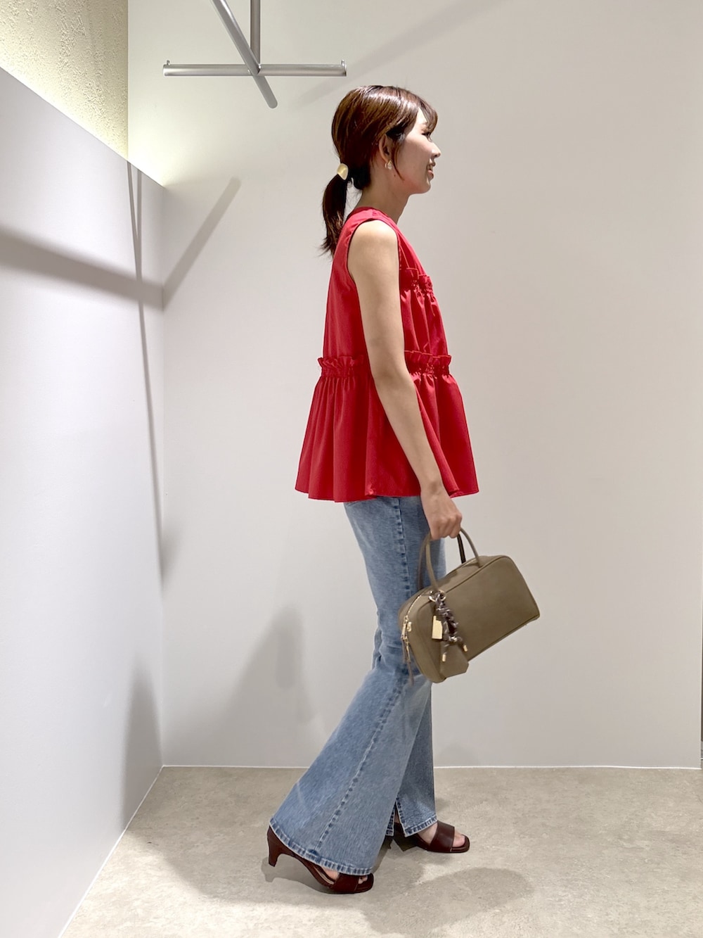 レッド系のシャツ/ブラウス、ブルー系のデニムパンツ、ブラック系のボストンバッグを着用したレディースの夏コーディネートの4枚目の写真