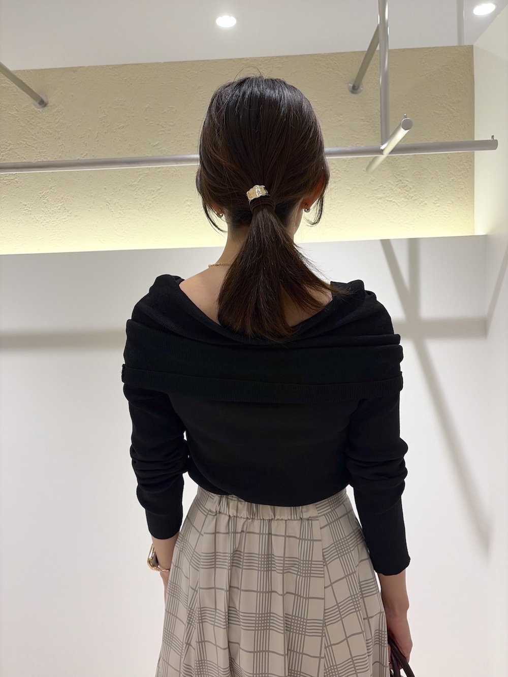 ブラック系のニット/セーター、ベージュ系のスカート、レッド系のボストンバッグを着用したレディースの秋コーディネートの8枚目の写真
