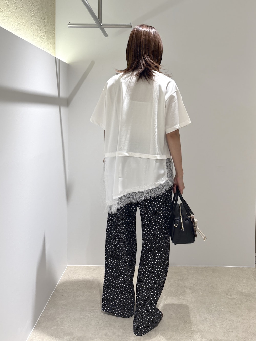 ホワイト系のTシャツ/カットソー、ブラック系のサンダル、ブラック系のボストンバッグを着用したレディースの夏コーディネートの3枚目の写真