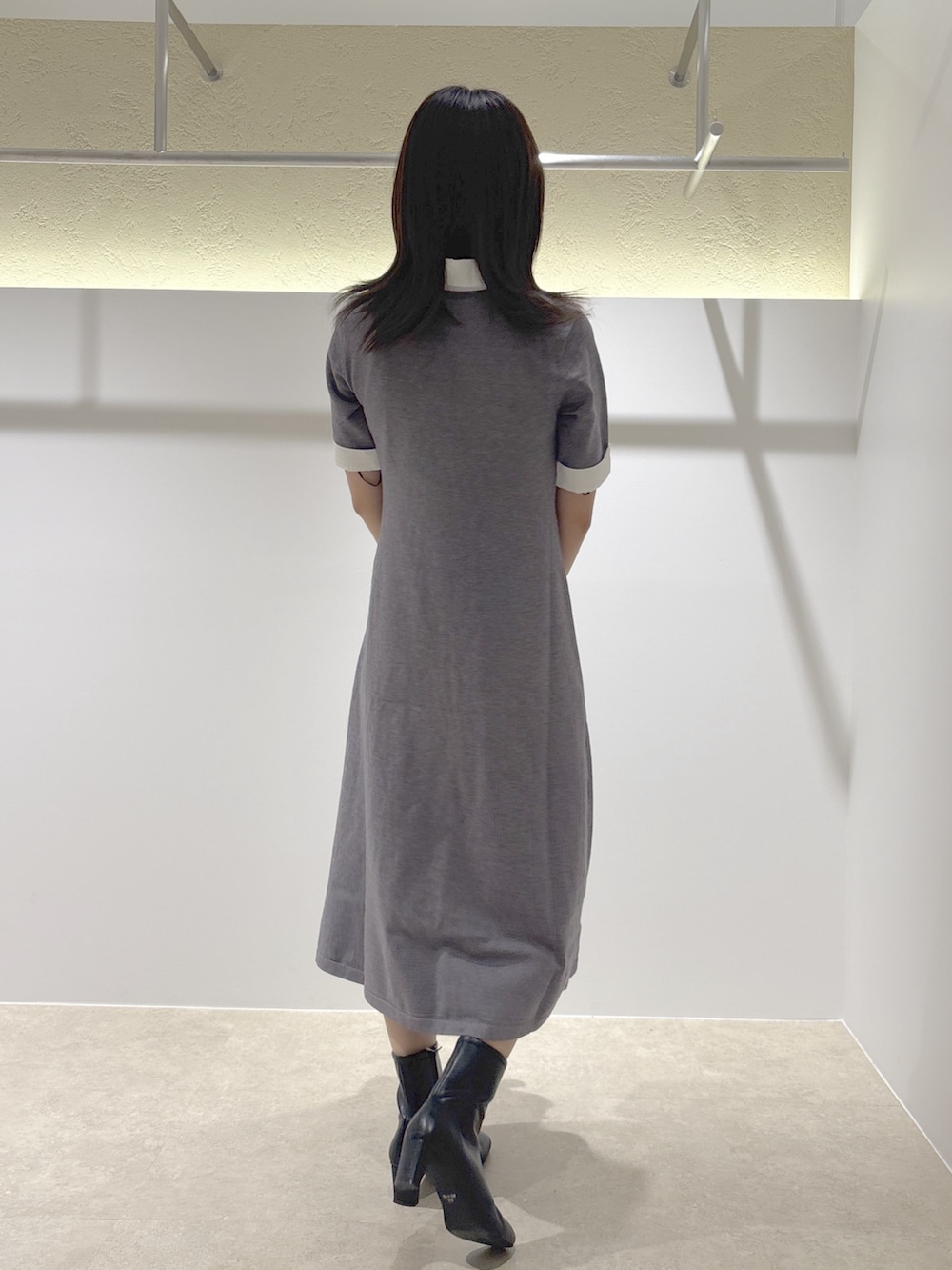 グレー系のワンピース、ブラック系のブーツ、ブラック系のトートバッグを着用したレディースの夏コーディネートの3枚目の写真