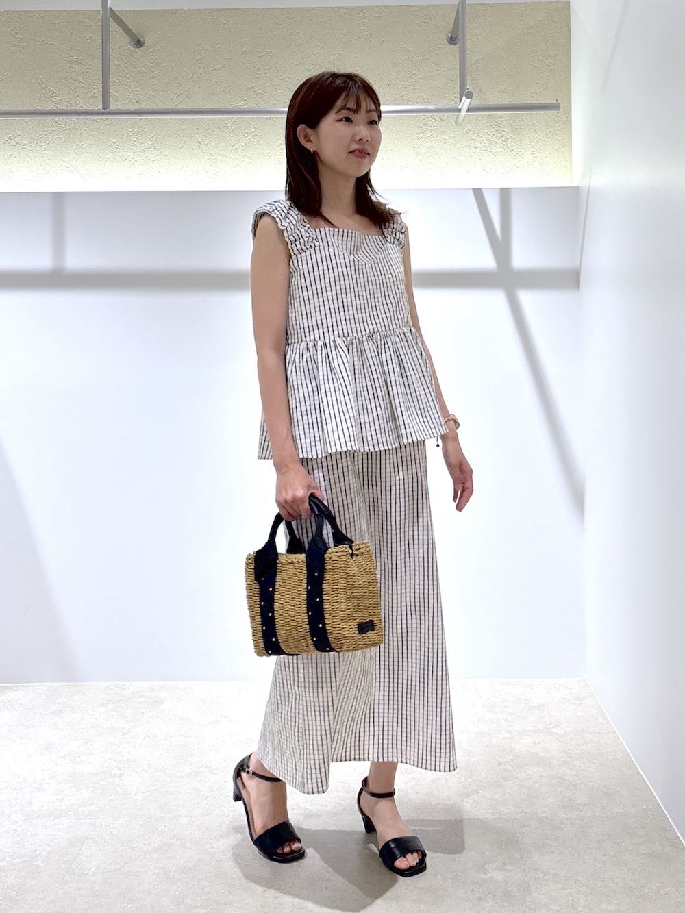 ホワイト系のシャツ/ブラウス、ホワイト系のワンピース、ベージュ系のかごバッグを着用したレディースの夏コーディネートの4枚目の写真
