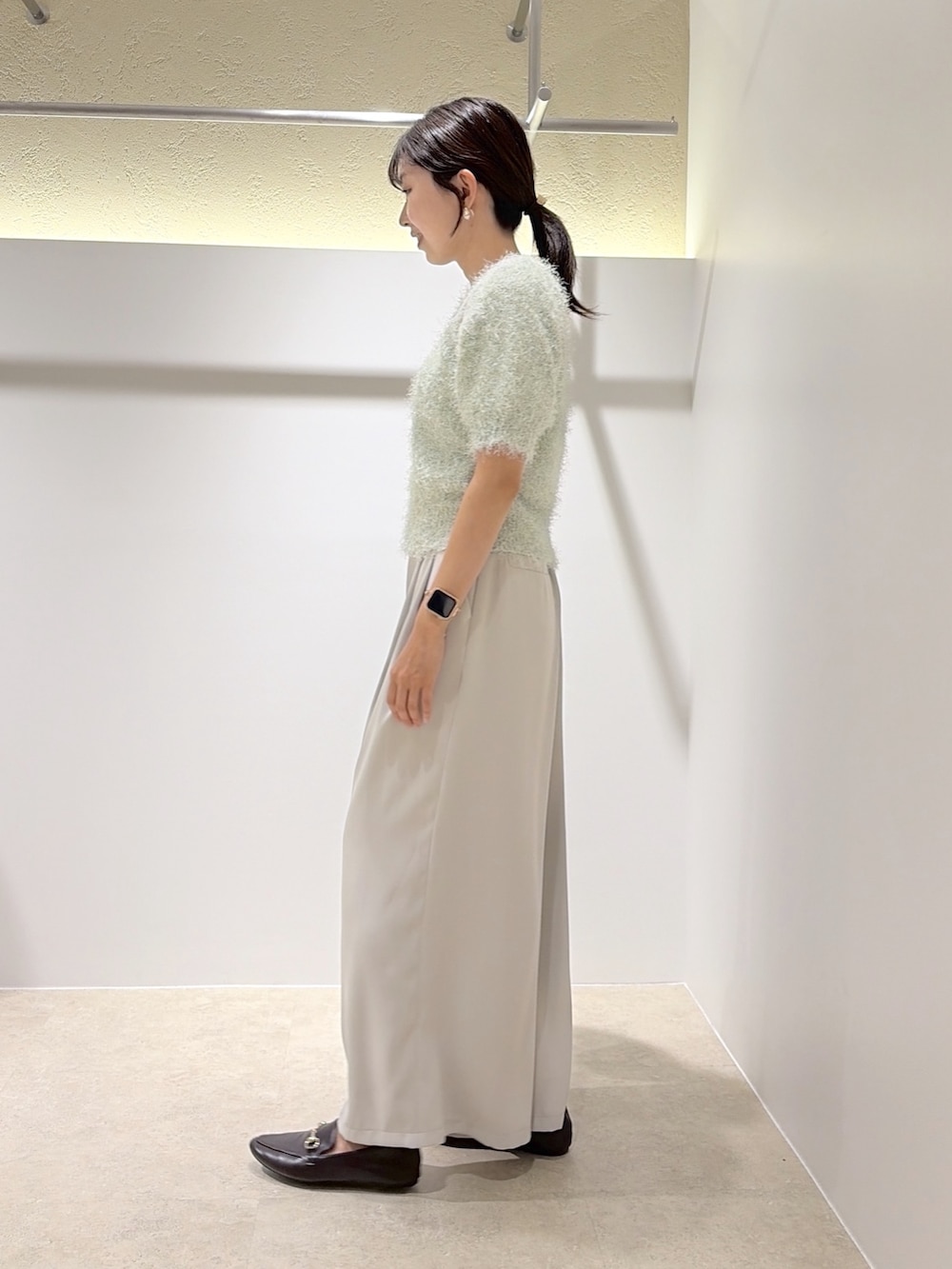 グリーン系のニット/セーター、ベージュ系のその他パンツ、ブラック系のローファーを着用したレディースの秋コーディネートの2枚目の写真