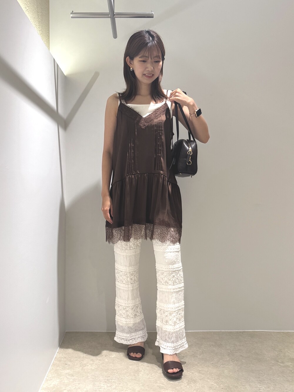 ブラウン系のキャミソール、ホワイト系のその他パンツ、ホワイト系のタンクトップを着用したレディースの夏コーディネートの4枚目の写真