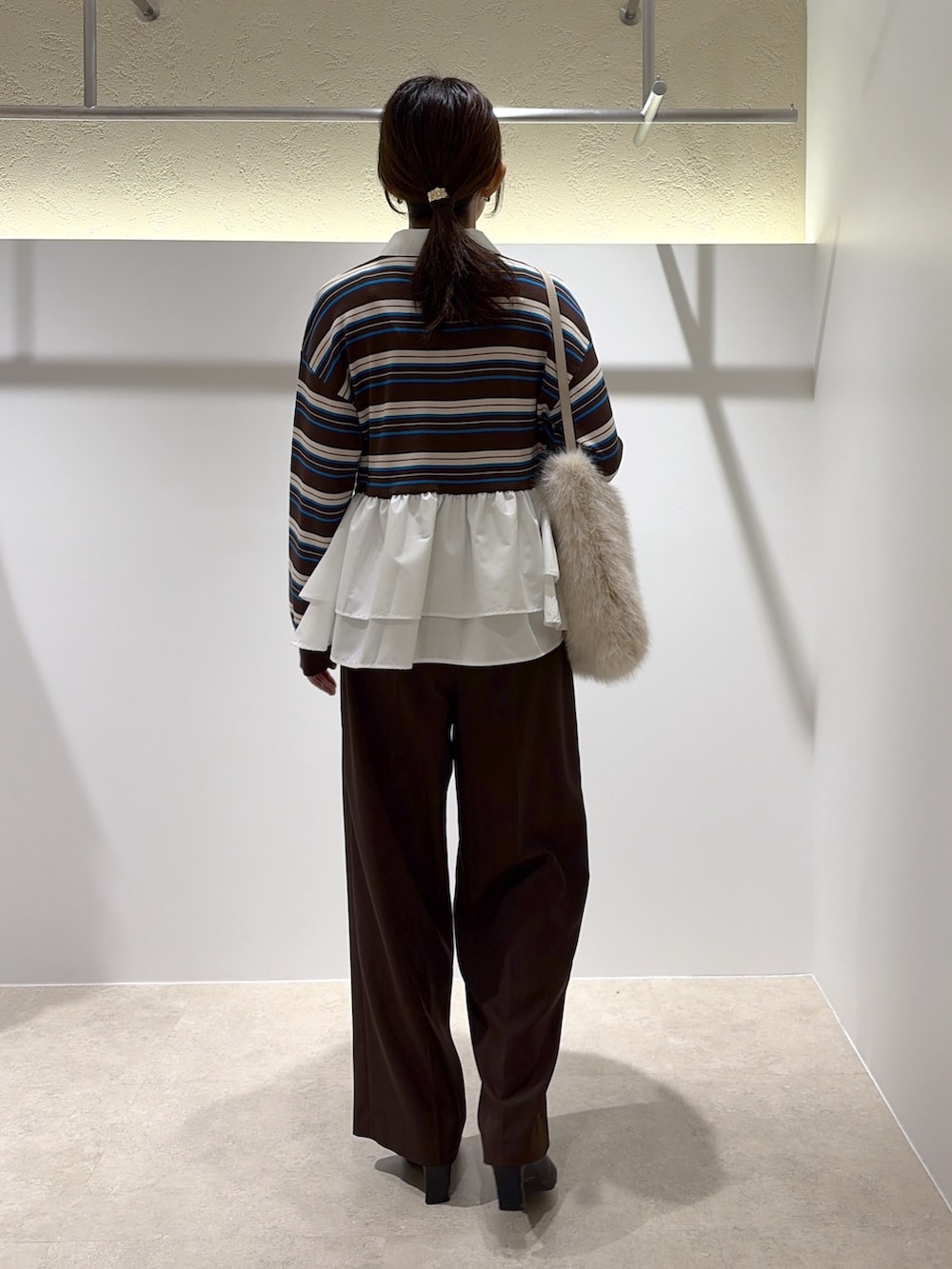 ブラウン系のニット/セーター、ブラウン系のその他パンツ、ホワイト系のショルダーバッグを着用したレディースの秋コーディネートの3枚目の写真